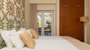 A bedroom with a bed, pillows, a wooden wardrobe, and a view of the outside. - Aires da Serra Hotel (Torres Novas)