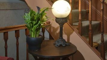 A staircase with wooden railings and a potted plant on a small table beside it.