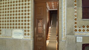 Une porte marron sur laquelle est apposée une enseigne indiquant « Dukes Corner Guest House », qui donne sur un escalier.