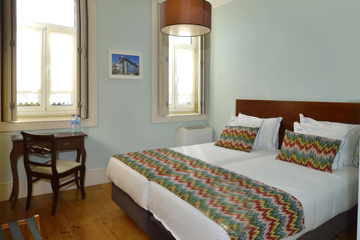 Ein ordentlich eingerichtetes Hotelzimmer mit einem großen Bett, einem Schreibtisch und einem Stuhl.