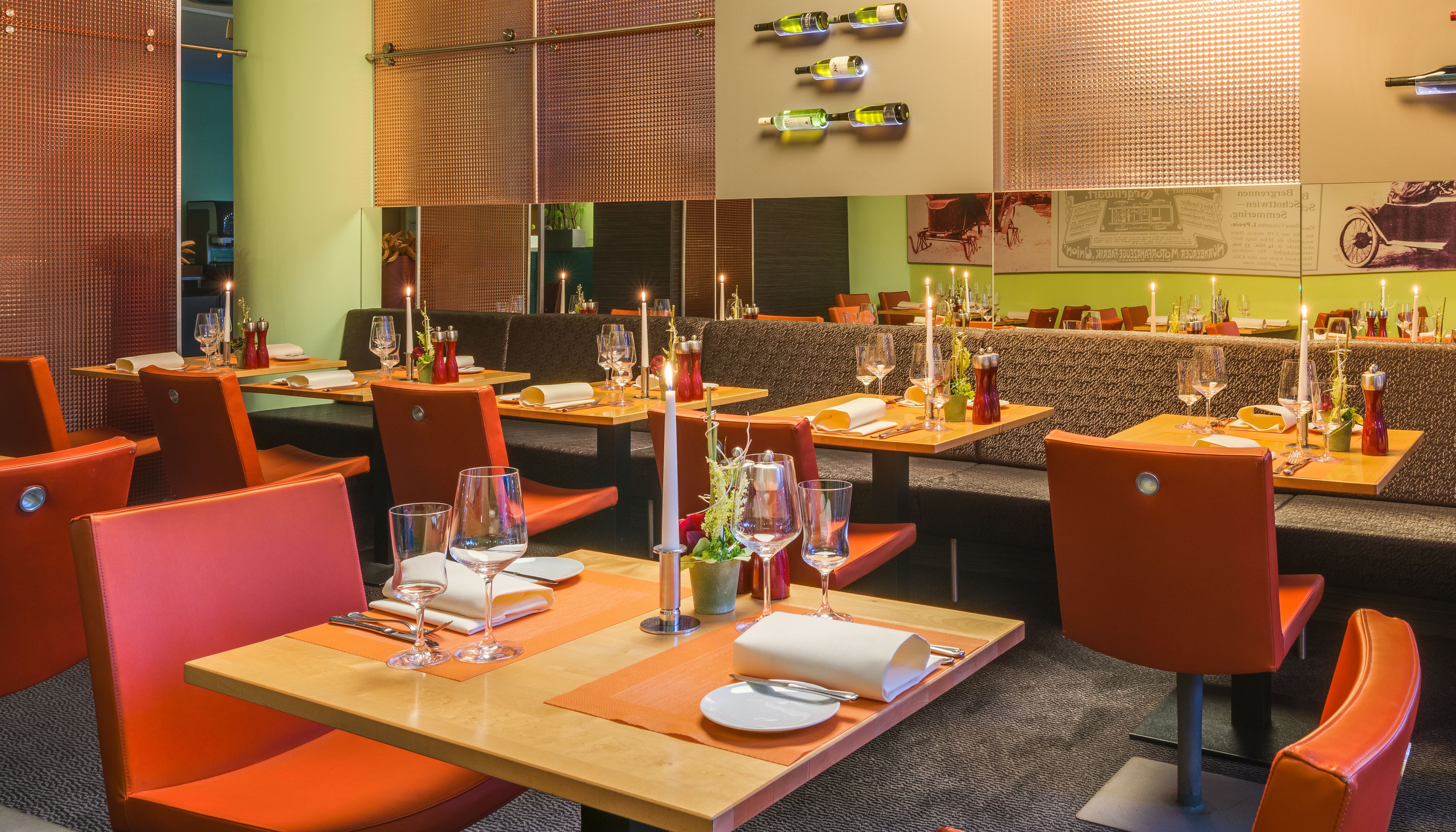 Un restaurante con varias mesas preparadas para comer, cada una con velas y copas de vino.