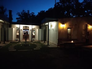A building with a covered outdoor area, a fountain, and a seating area with a table and chairs. - Hostel Punta Ballena Bar (Punta Ballena)