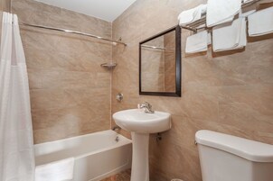 A bathroom with a bathtub, a sink, and a toilet.
