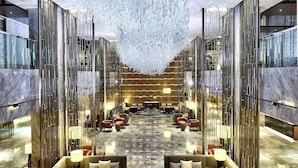 A spacious lobby with a large chandelier, seating areas, and a patterned carpet. - Hilton Kota Kinabalu (Kota Kinabalu)