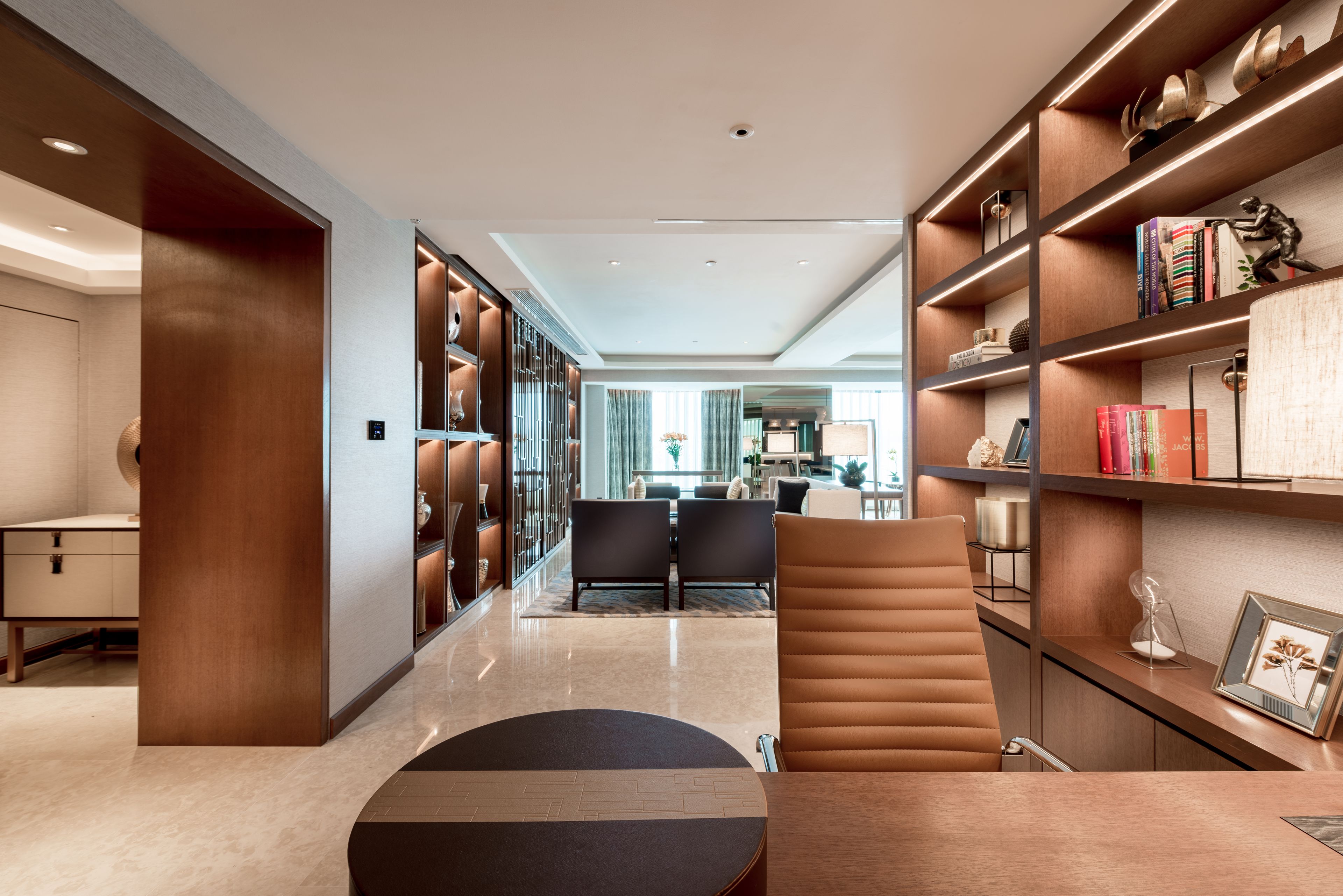 A modern interior with a seating area, a bookshelf, and a desk.