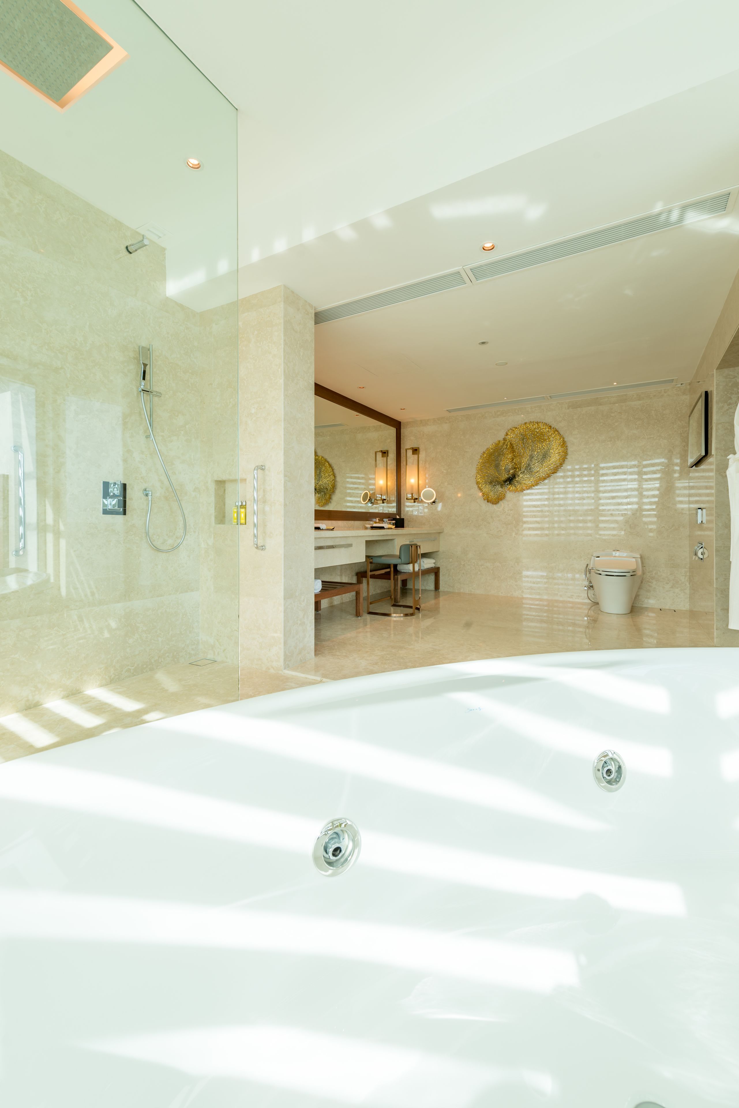 A modern bathroom with a glass-enclosed shower, a large bathtub, and a vanity with a mirror.