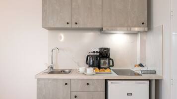 Uma cozinha compacta com cafeteira, pia e lava-louças.