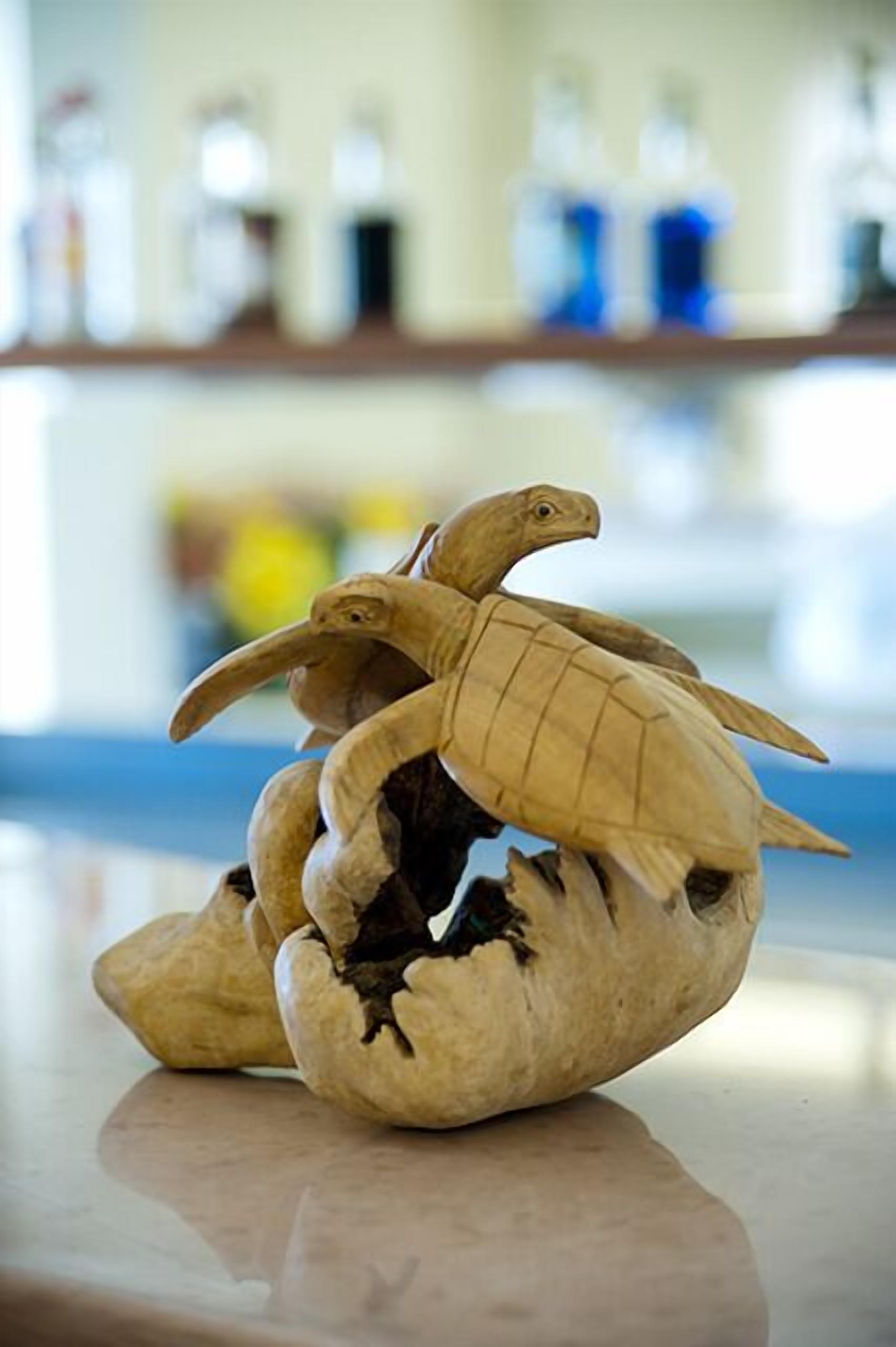 Une sculpture d’un oiseau doté d’un grand bec et d’ailes, placée sur une table.