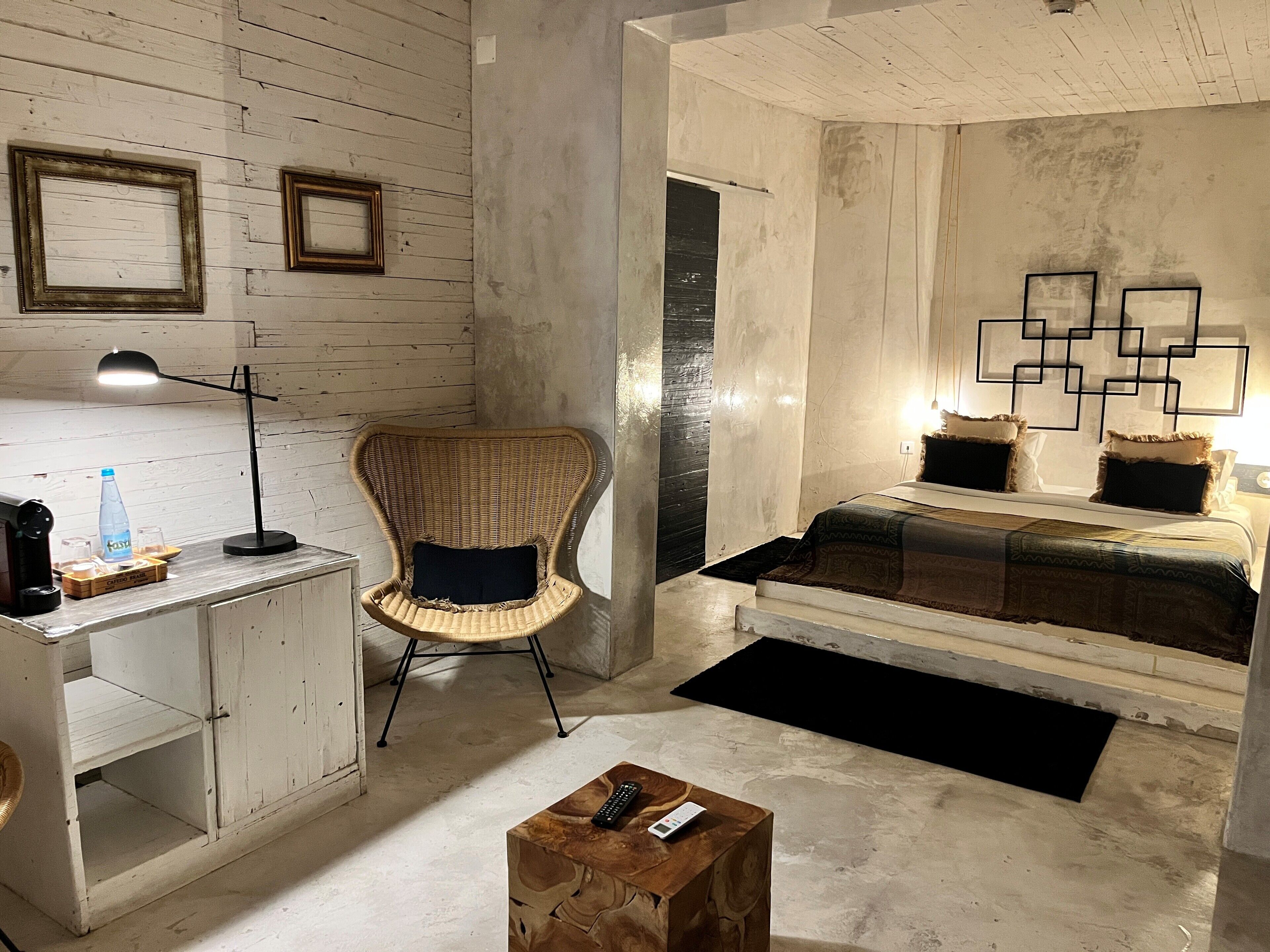 Una habitación con cama, una silla, un escritorio y una mesita de centro.