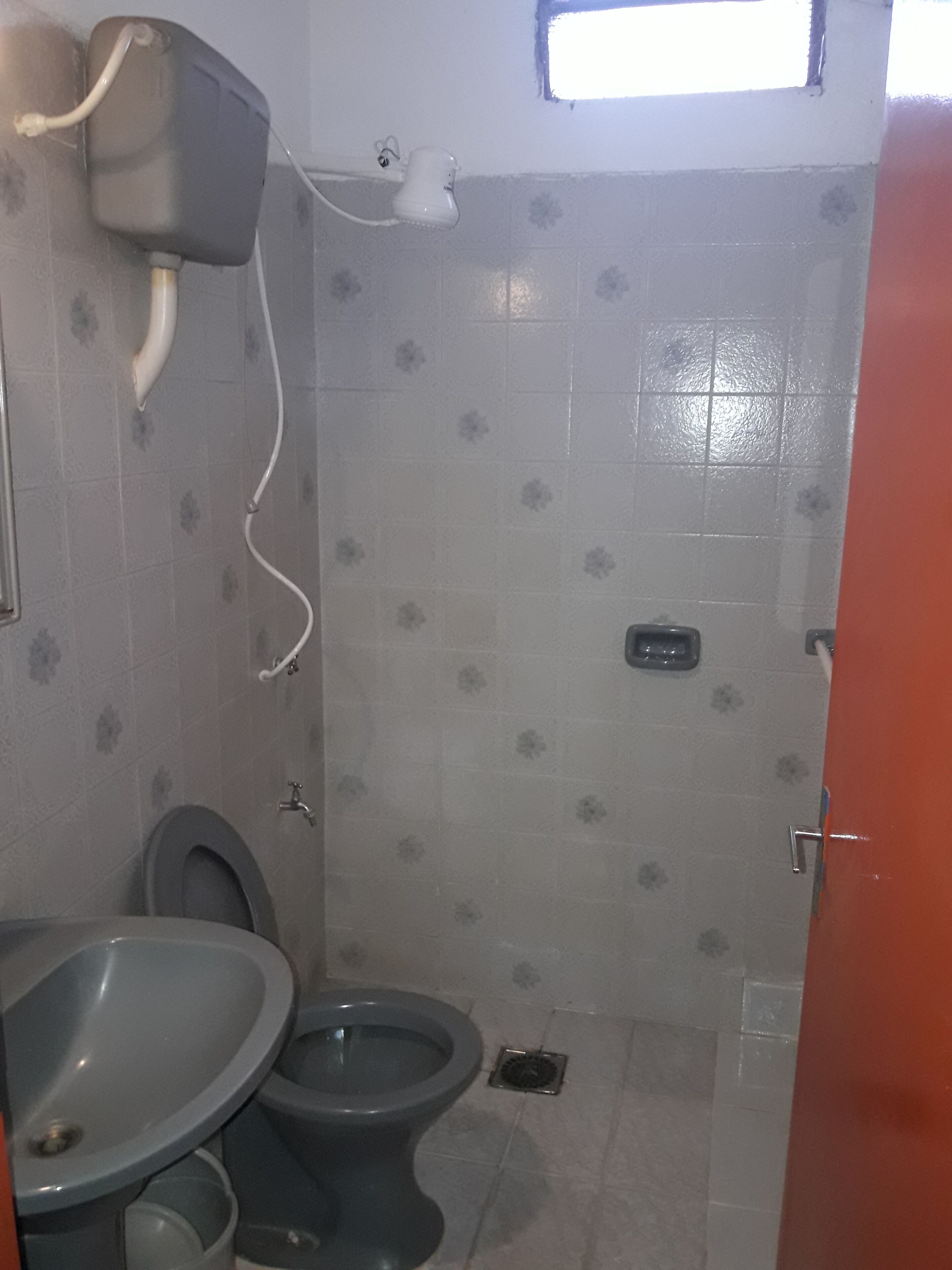 Een kleine badkamer met toilet, wastafel en douche.