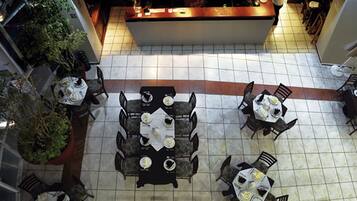 Un ristorante con diversi tavoli e sedie, un pavimento piastrellato e un bancone.