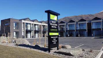 Ein modernes Motel mit einem Schild, das 44 Cardrona Valley Road anzeigt, mit 20 luxuriösen Zimmern, Studios, Ein-Zimmer-Apartments und Familienzimmern.