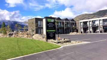 A modern motel with a sign indicating 20 luxury units, including studio, one-bedroom, and family rooms.