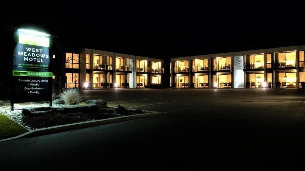 Motel West Meadows, con un cartel que indica 20 unidades de lujo, incluyendo estudios, habitaciones de una habitación y habitaciones familiares.