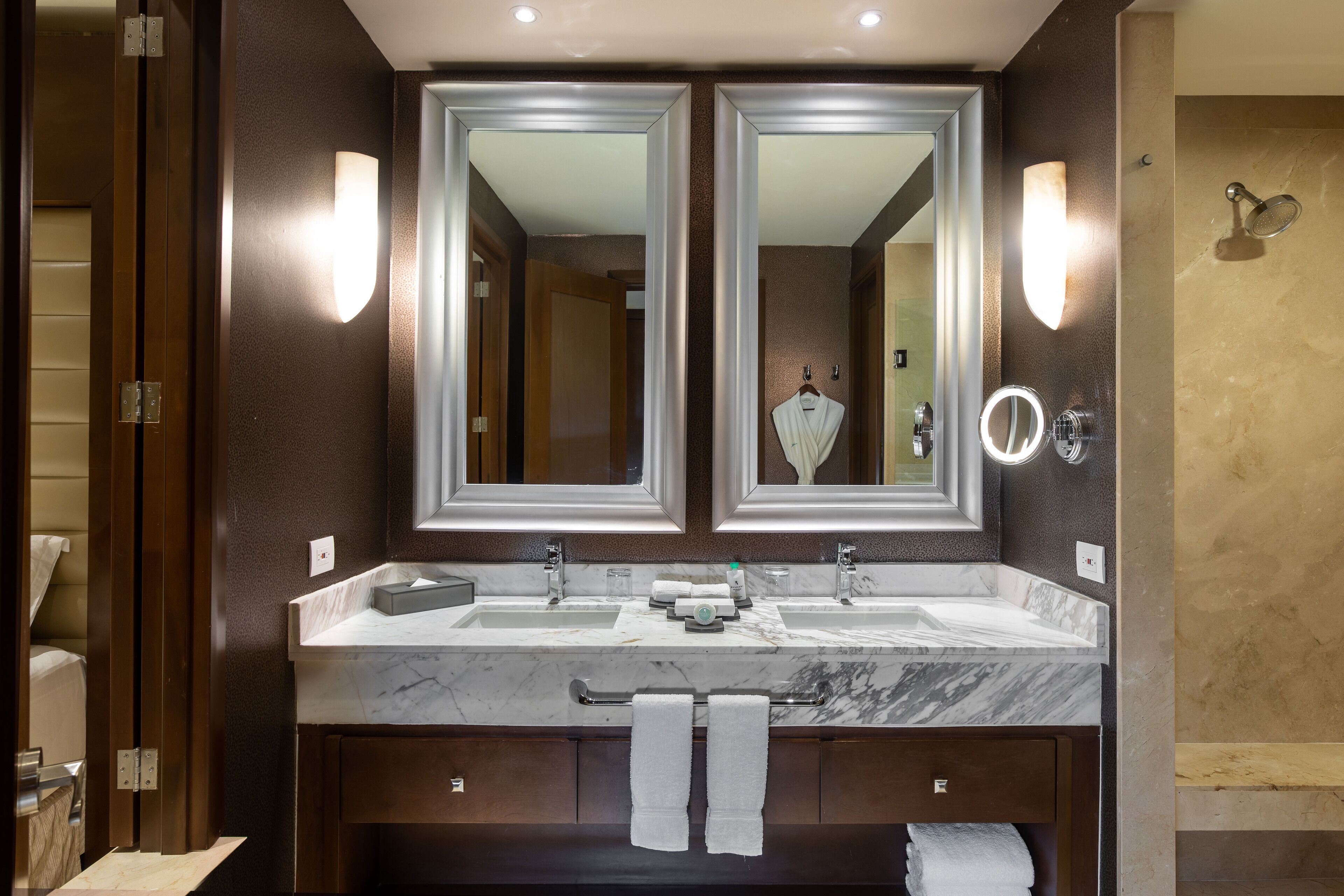A modern bathroom with a double sink, large mirrors, and a towel rack.