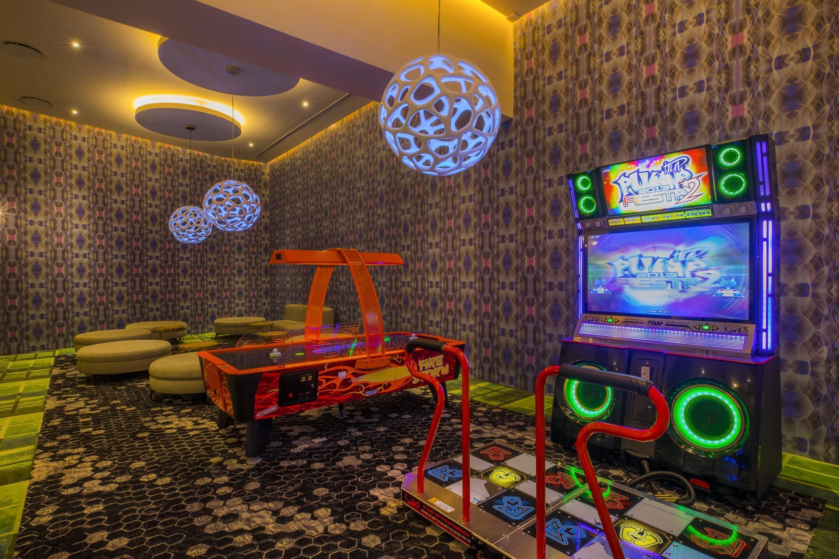 A gaming area with arcade machines, a fire hydrant-shaped table, and patterned wallpaper.