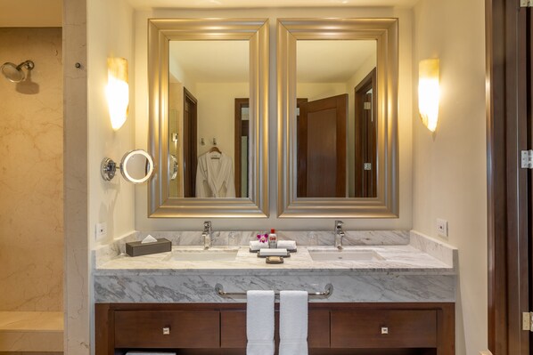 A bathroom with a double sink, two large mirrors, and a towel rack.