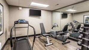 A gym with a treadmill, exercise bike, and weight bench. - Quality Inn Pleasant View (Pleasant View)