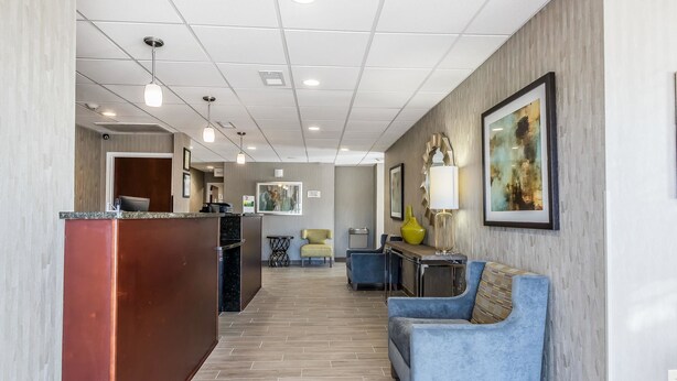 A hotel lobby with a reception desk, seating area, and artwork on the walls. - Quality Inn Pleasant View (Pleasant View)