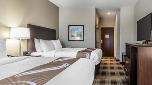 A hotel room with two beds, a desk, a TV, and a framed picture on the wall. - Quality Inn Pleasant View (Pleasant View)