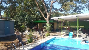 Un área de piscina con sillones de descanso y una pequeña estatua de elefante.
