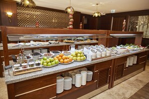 A buffet with various food items and a glass display case. - Ramada Resort by Wyndham Kazdaglari Thermal and Spa (Edremit)