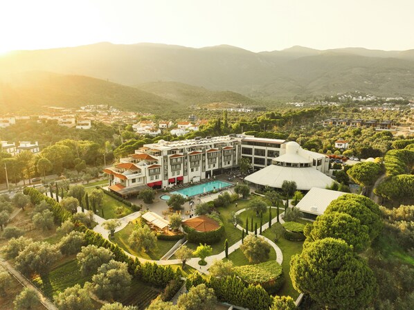 A hotel with a swimming pool, surrounded by landscaped gardens and a mountainous backdrop. - Ramada Resort by Wyndham Kazdaglari Thermal and Spa (Edremit)
