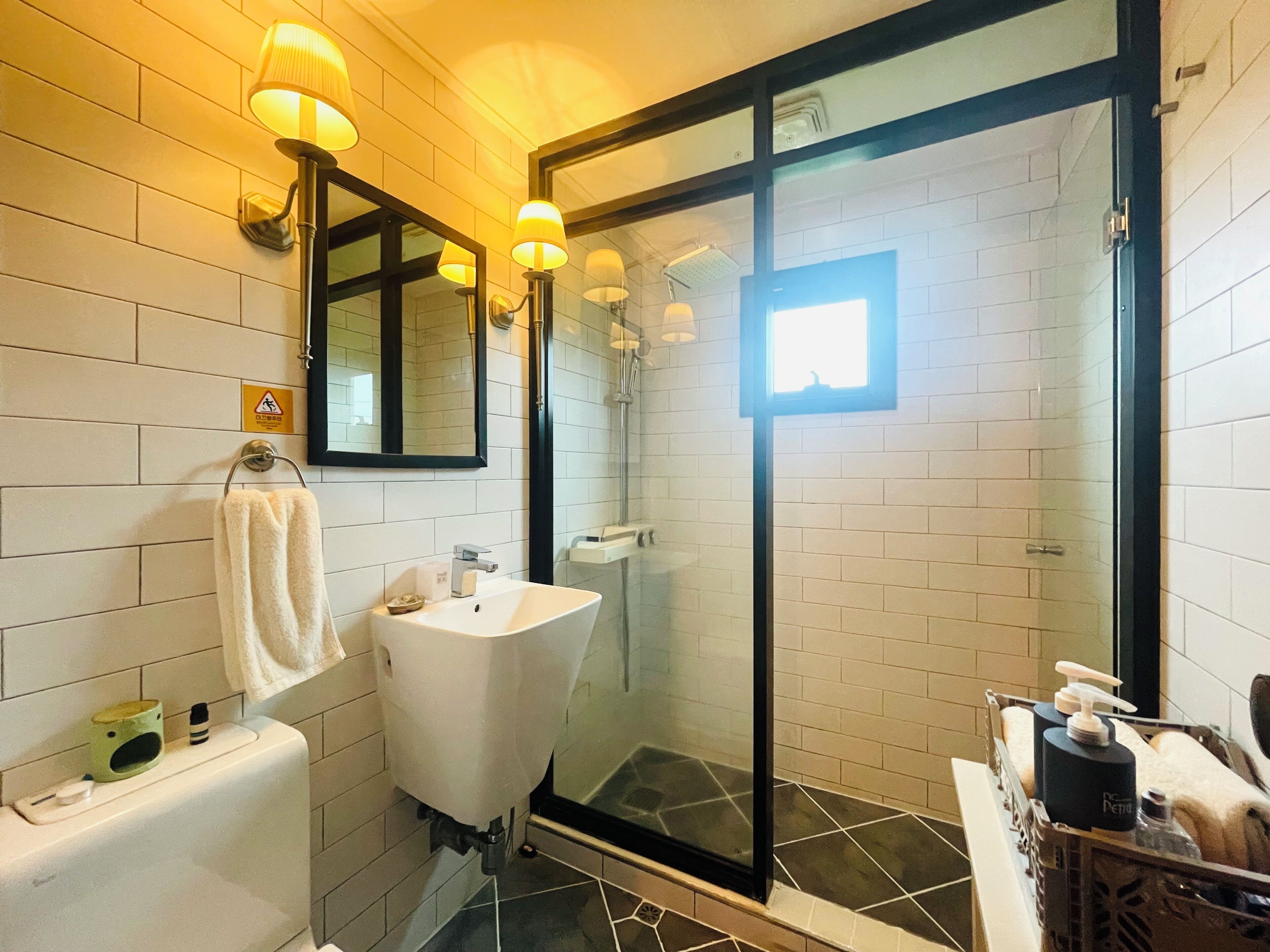 Un baño moderno con lavamanos independiente, ducha con cerramiento de vidrio y un perchero para toallas.