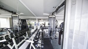 A gym with weightlifting equipment, treadmills, and exercise machines. - Hyde Park Residence by PSR ASIA (Pattaya)