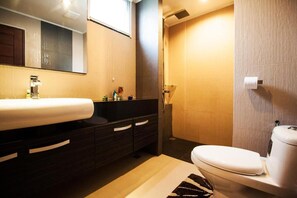 Een moderne badkamer met een groot wastafel, een donkere wastafelmeubel en een toilet.
