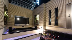 A modern kitchen with a built-in oven, a large window, and a dining area with a table set for two. - Hotel Gransky - Adults Only (Tokyo)