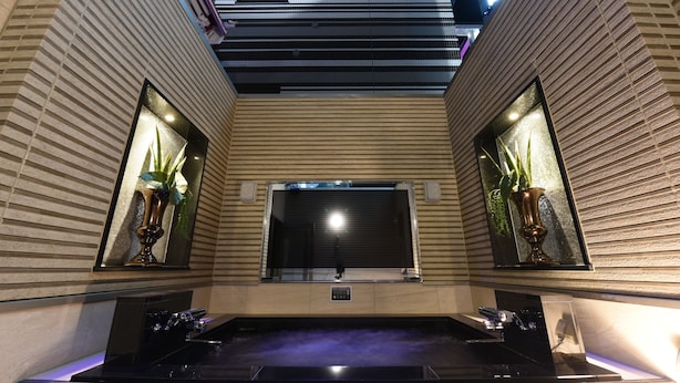 A spa area with a hot tub, two potted plants, and a large mirror. - Hotel Gransky - Adults Only (Tokyo)