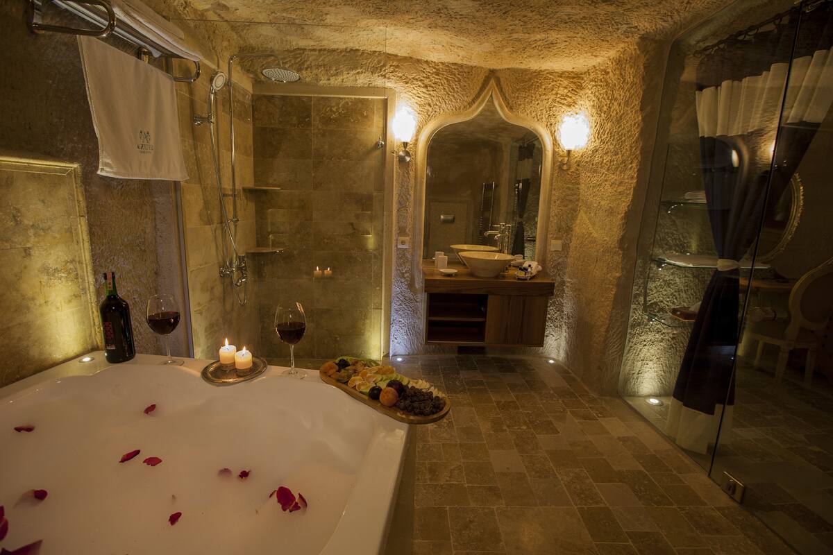 A luxurious bathroom with a large bathtub, a mirror, and a vanity with a sink.