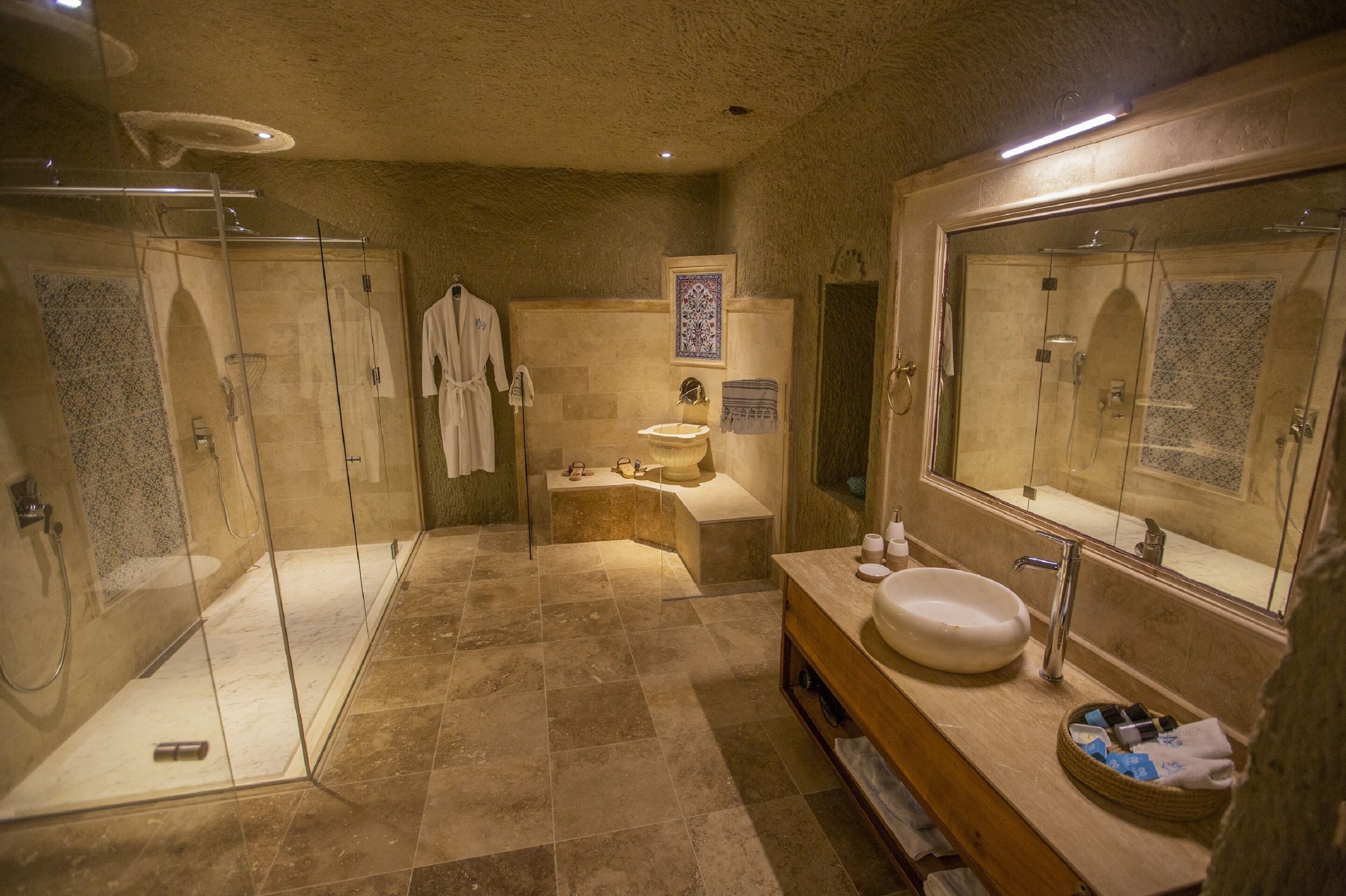 A bathroom with a glass-enclosed shower, a sink with a large mirror, and a bathtub.