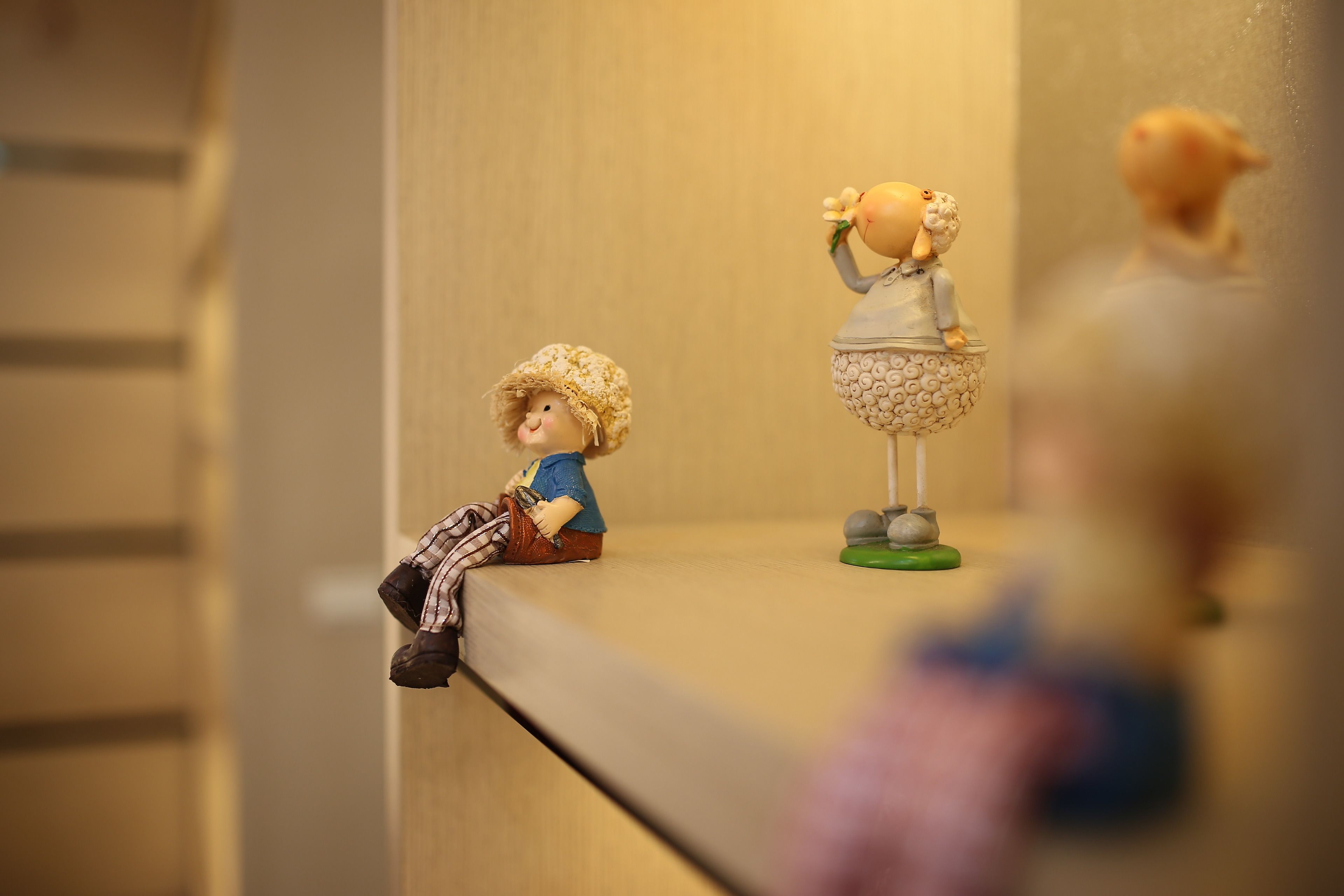 A small figurine of a boy and a girl on a shelf.