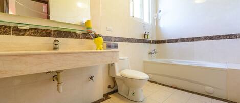 Un baño con inodoro, lavabo y bañera.