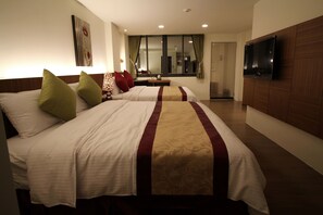 Une chambre d’hôtel avec deux lits, une télévision et une fenêtre avec des rideaux.