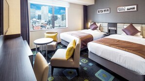 A hotel room with two beds, a sofa, a small table, and a view of a cityscape. - Hotel Mystays Premier Akasaka (Tokyo)