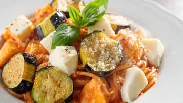 Un plato de espagueti con verduras y queso.