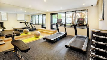 Ett gym med löpband, träningsbollar och styrketräningsmaskiner.
