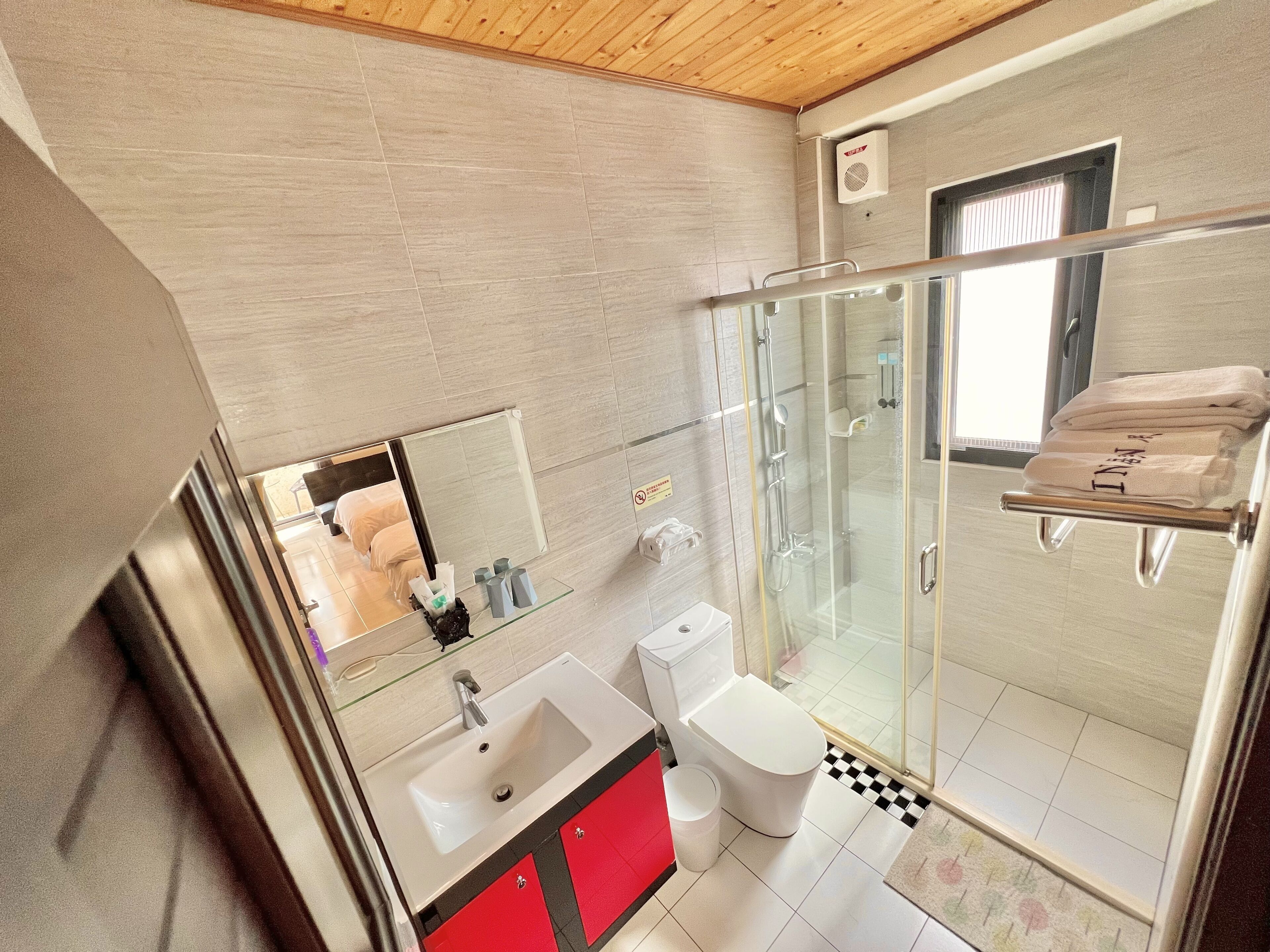 Ein modernes Badezimmer mit einer Duschkabine, einem weißen Waschbecken und einer Toilette.