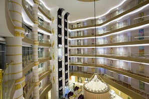 A multi-level hotel interior with a central atrium, glass railings, and a chandelier. - Water Side Resort & Spa (Manavgat)