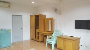 A room with a wardrobe, a desk with a chair, a television, and a refrigerator. - Mood Mansion (Kamala)