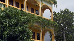 A multi-story building with balconies, arched windows, and a yellow facade. - Mood Mansion (Kamala)