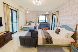 A hotel room with a large bed, two sofas, a TV, and a view of the outdoors. - Shan Hai B&B (Ji'an)