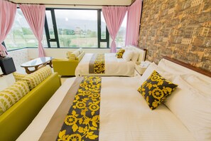 A hotel room with two beds, a green sofa, a small table, and a view of the outdoors. - Shan Hai B&B (Ji'an)