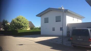 A modern two-story house with a white exterior, a garage, and a parked van.