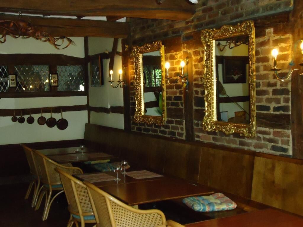 Un ristorante con parete in mattoni, arredi in legno e specchi decorati.