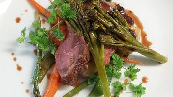 A plate of food with meat, vegetables, and sauce.