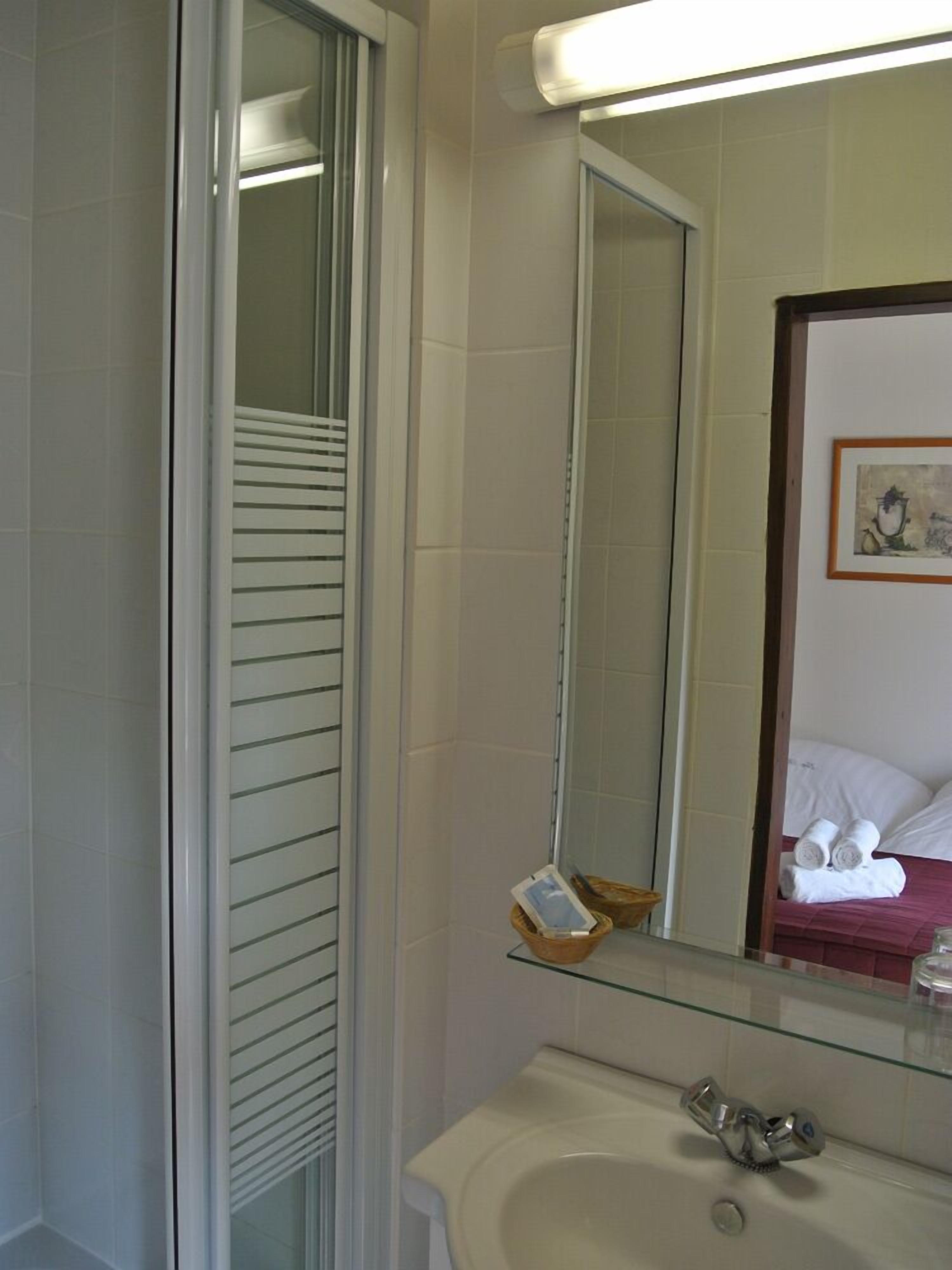 Une salle de bain avec des toilettes, un lavabo et un miroir.